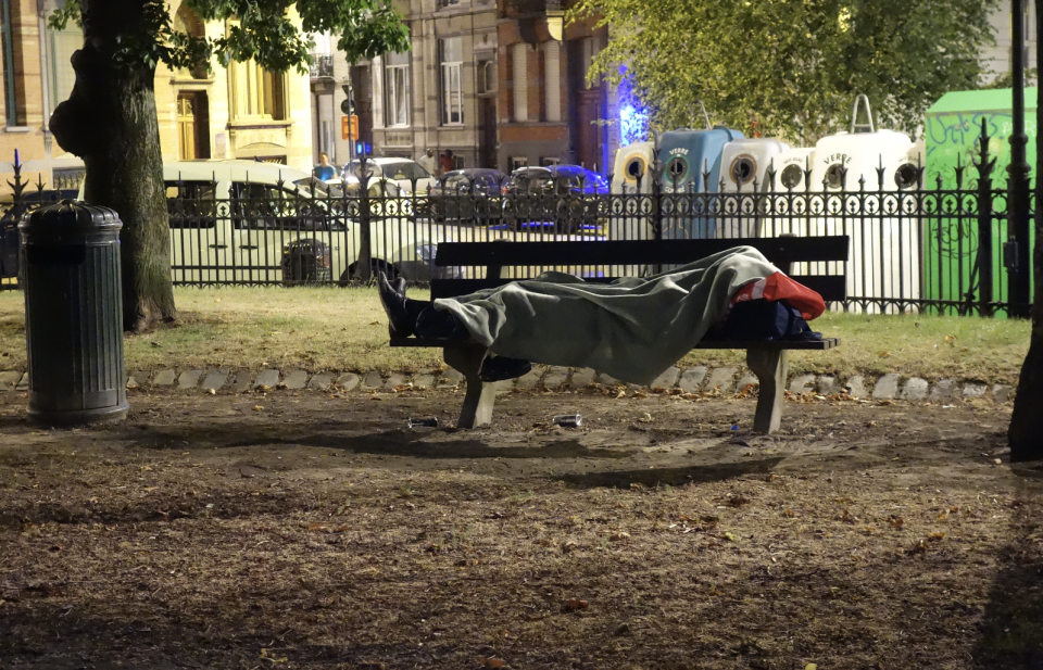 EEn bank met een dakloze mesn in een park